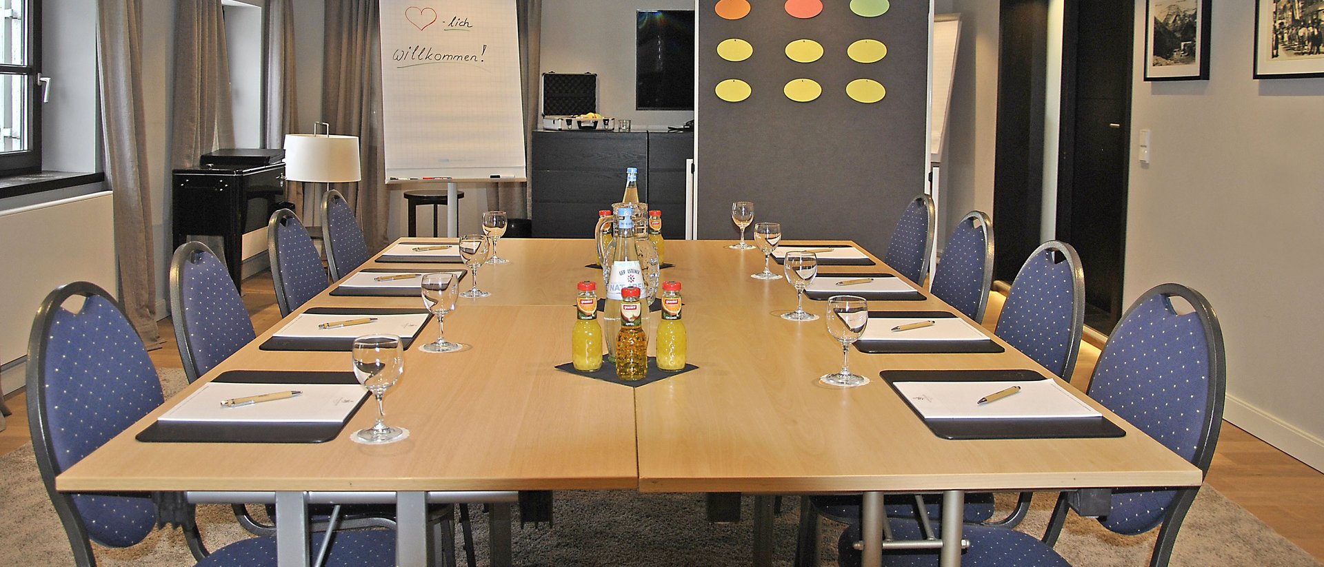 Your conference in our hotel Modern conference room with U-shaped table, chairs, and flipchart with welcome message