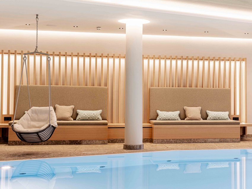 Your Hotel Bayerischer Hof in Oberstaufen Modern indoor pool with hanging basket chair and cushioned benches